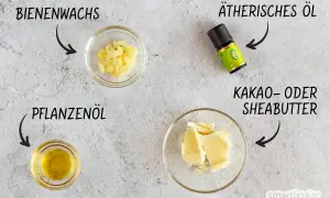 Zutaten für selbstgemachte Salbe mit Bienenwachs: Bienenwachs-Pellets, Pflanzenöl, Kakaobutter und ätherisches Öl.