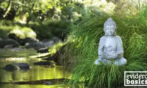 Buddha-Statue im Gras am Flussufer, eine Szene, die Achtsamkeit und eine friedliche Geschichte ausstrahlt.