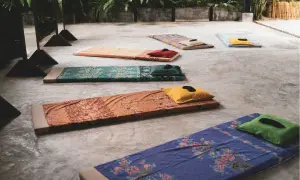 Bunte Matten mit Kissen liegen bereit für ein Retreat. Hier kann man zur Ruhe kommen und neue Energie tanken.