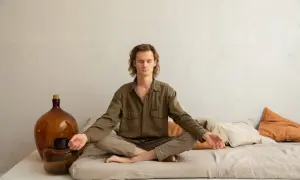 Mann in Lotusposition, Augen geschlossen, Arme entspannt. Ein Mann findet Ruhe durch Meditation gegen Depression.