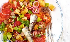 Bunter Salat mit Tomaten, Brot-Croutons, Zwiebeln und zwei ganzen Sardinen. Ein köstlicher Sardinensalat für den Sommer.