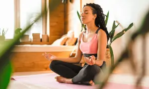 Eine junge Frau meditiert in Lotusposition. Ihre Augen sind geschlossen, Hände im Gyan Mudra. Eine Szene, die an eine Zen-Meister Geschichte erinnert, voller Achtsamkeit und innerer Ruhe.