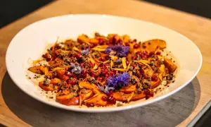 Bunter Salat mit Kürbis, Granatapfelkernen und Blüten. Ein Gericht, das sich gut für Kapha Rezepte eignet.