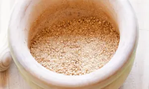 Mörser mit geröstetem Sesam und Salz für ein einfaches Gomasio Rezept.