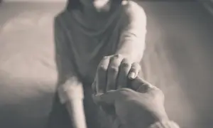 Zwei Hände halten sich fest. Die eine Hand ist zart, die andere wirkt kräftiger. Ein Symbol für Unterstützung, vielleicht gegen energievampire symptome.