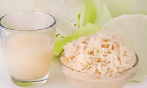 Ein Glas Sauerkrautsaft und eine Schüssel Sauerkraut, um die positive Sauerkrautsaft Wirkung Leber zu unterstützen.