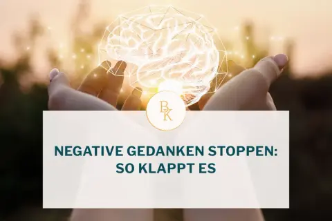 Hände halten ein leuchtendes Gehirn. Der Text fragt: "Negative Gedanken stoppen: So klappt es". Lerne, wie werde ich negative gedanken los.