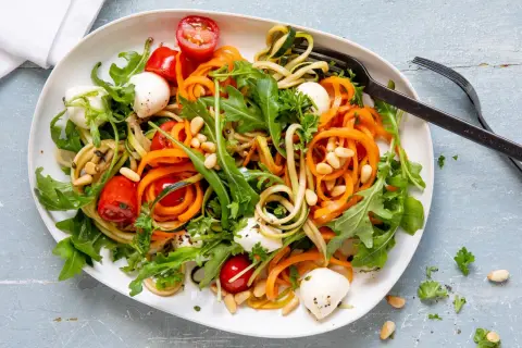 Bunter Zoodles Salat mit Karottenstreifen, Mozzarella-Kugeln, Kirschtomaten und Pinienkernen. Ein leichter Genuss!