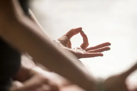 Nahaufnahme einer Hand in Mudra-Geste, die die "Om Tare Tuttare Wirkung" symbolisiert.