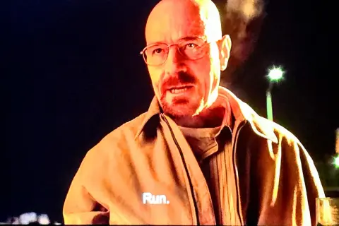 Walter White, mit einem humorvollen Umgang mit dem Tod, sagt "Run." auf seiner Jacke.