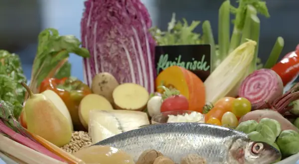 Frisches Gemüse, Fisch und Nüsse auf einem Teller. Eine gute Wahl für eine Ernährung bei Gicht, die auch Eier einschließen kann.