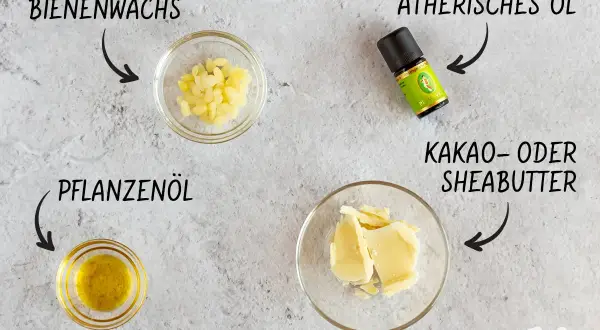 Zutaten für selbstgemachte Salbe mit Bienenwachs: Bienenwachs-Pellets, Pflanzenöl, Kakaobutter und ätherisches Öl.