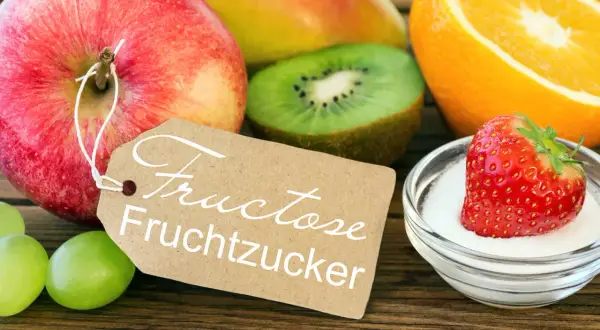 Obst und eine Erdbeere in Zucker, mit Schild "Fructose Fruchtzucker". Achtung bei Fructoseintoleranz!
