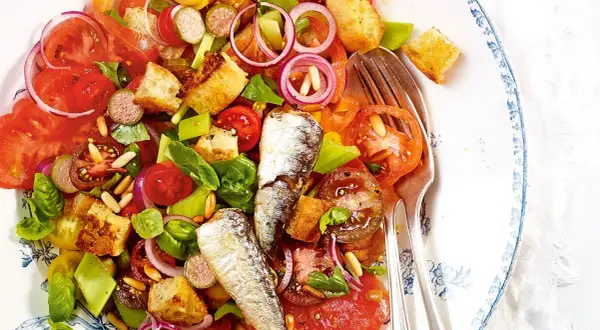 Bunter Salat mit Tomaten, Brot-Croutons, Zwiebeln und zwei ganzen Sardinen. Ein köstlicher Sardinensalat für den Sommer.