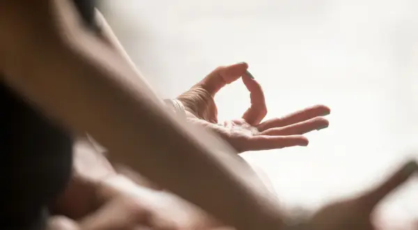 Nahaufnahme einer Hand in Mudra-Geste, die die "Om Tare Tuttare Wirkung" symbolisiert.
