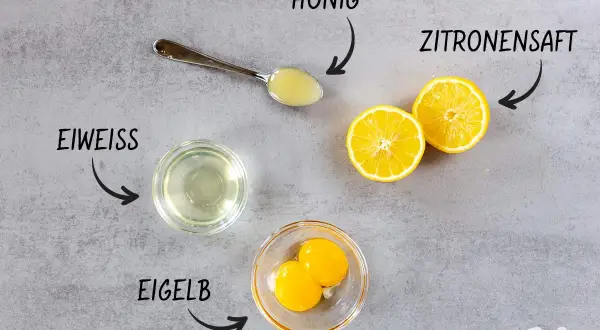 Zutaten für eine natürliche Haarpflege: Eiweiß, Eigelb, Honig und Zitronensaft. Perfekt, um die Haare mit Ei zu waschen!