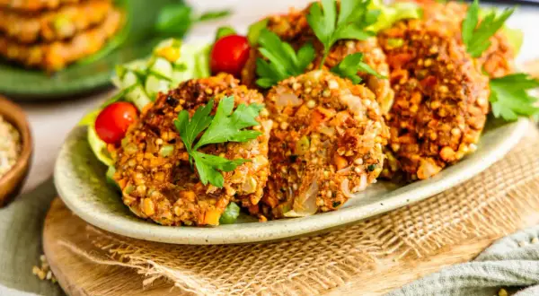 Herzhafte buchweizen bratlinge mit frischem Salat und Kirschtomaten, garniert mit Petersilie.