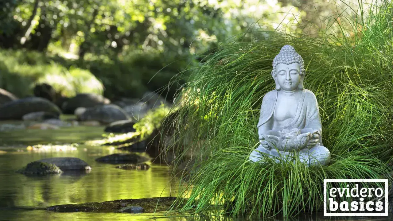 Buddha-Statue im Gras am Flussufer, eine Szene, die Achtsamkeit und eine friedliche Geschichte ausstrahlt.