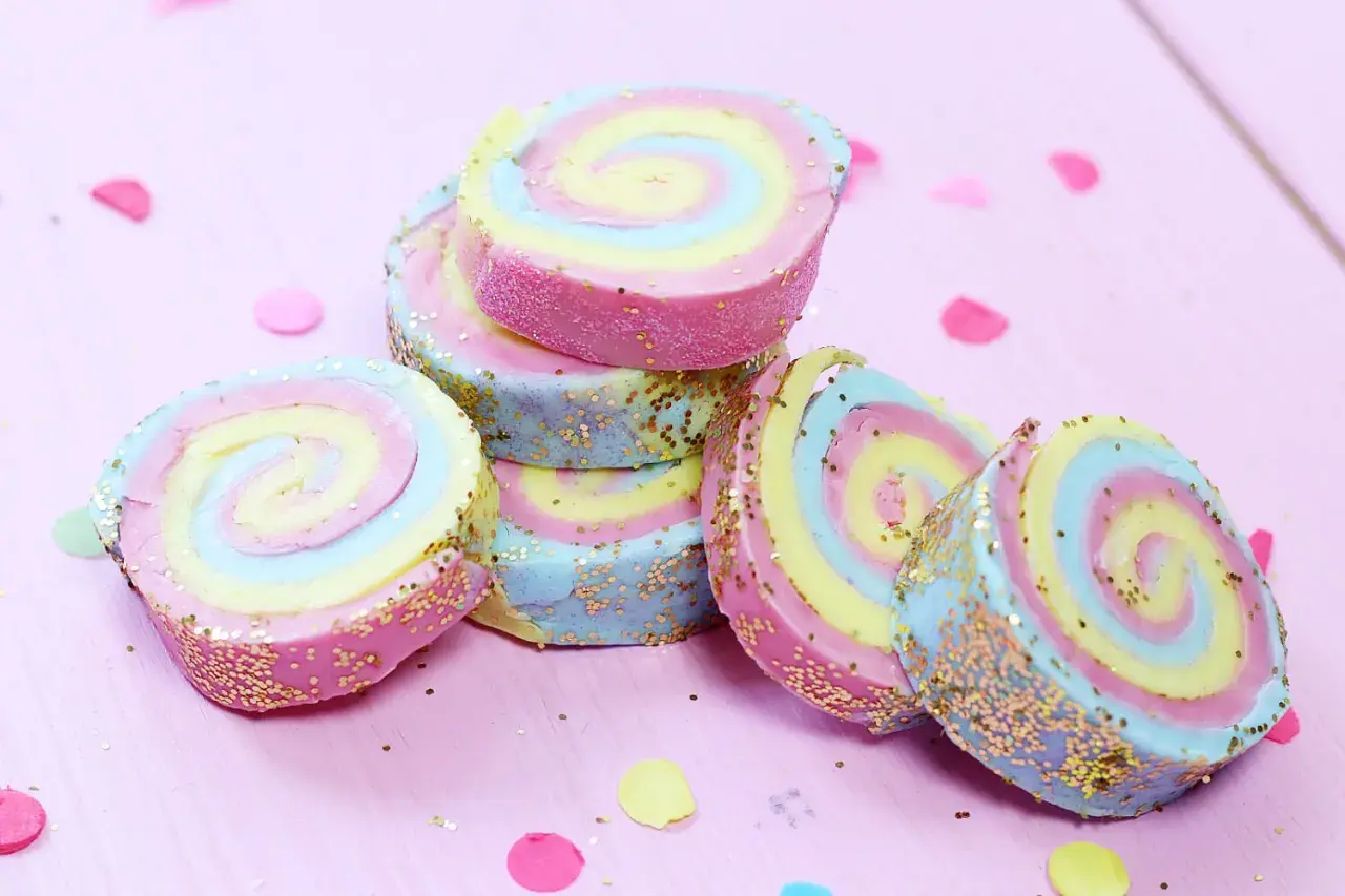 Bunte Seifenstücke mit Glitzer, die an bunte Rollen erinnern. Perfekt zum **Seife basteln** für kleine und große Künstler.
