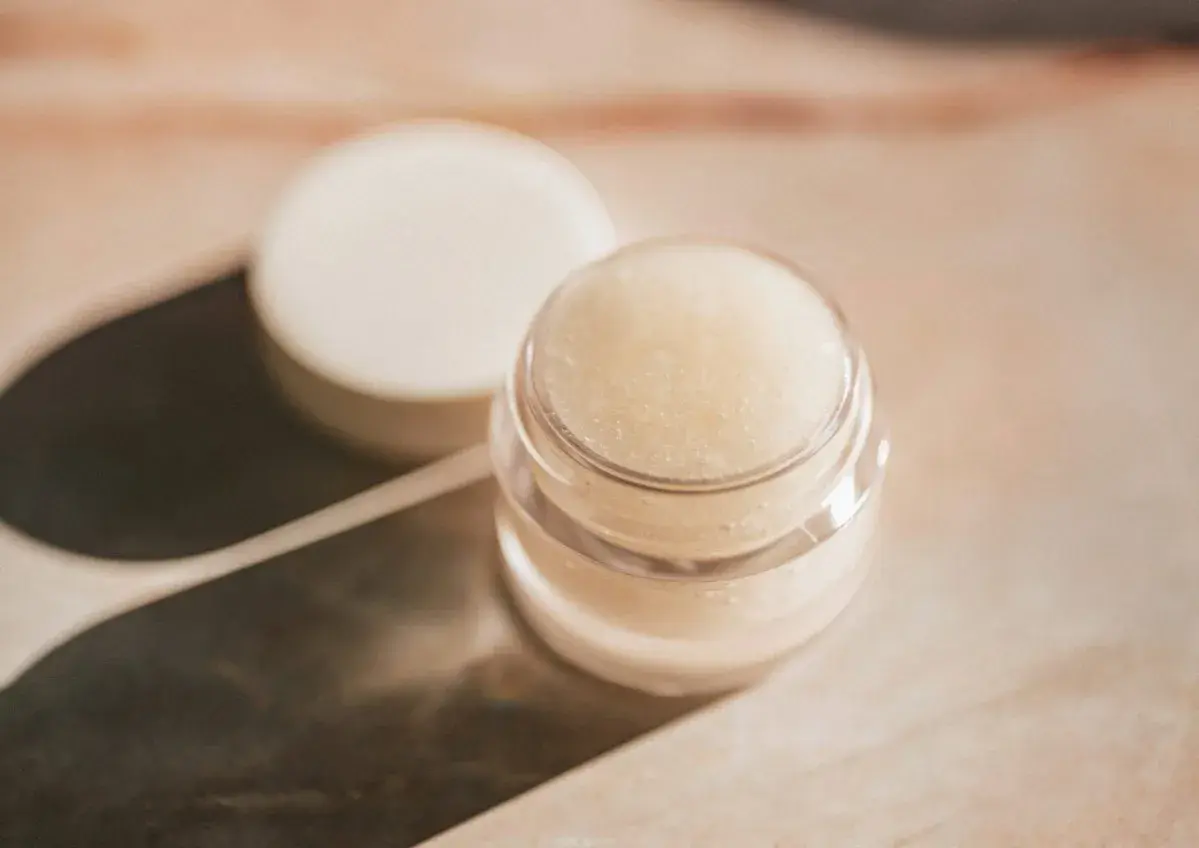 Ein kleiner Tiegel mit selbstgemachter Augencreme, daneben der Deckel. Perfekt für alle, die Augencreme selber machen wollen.