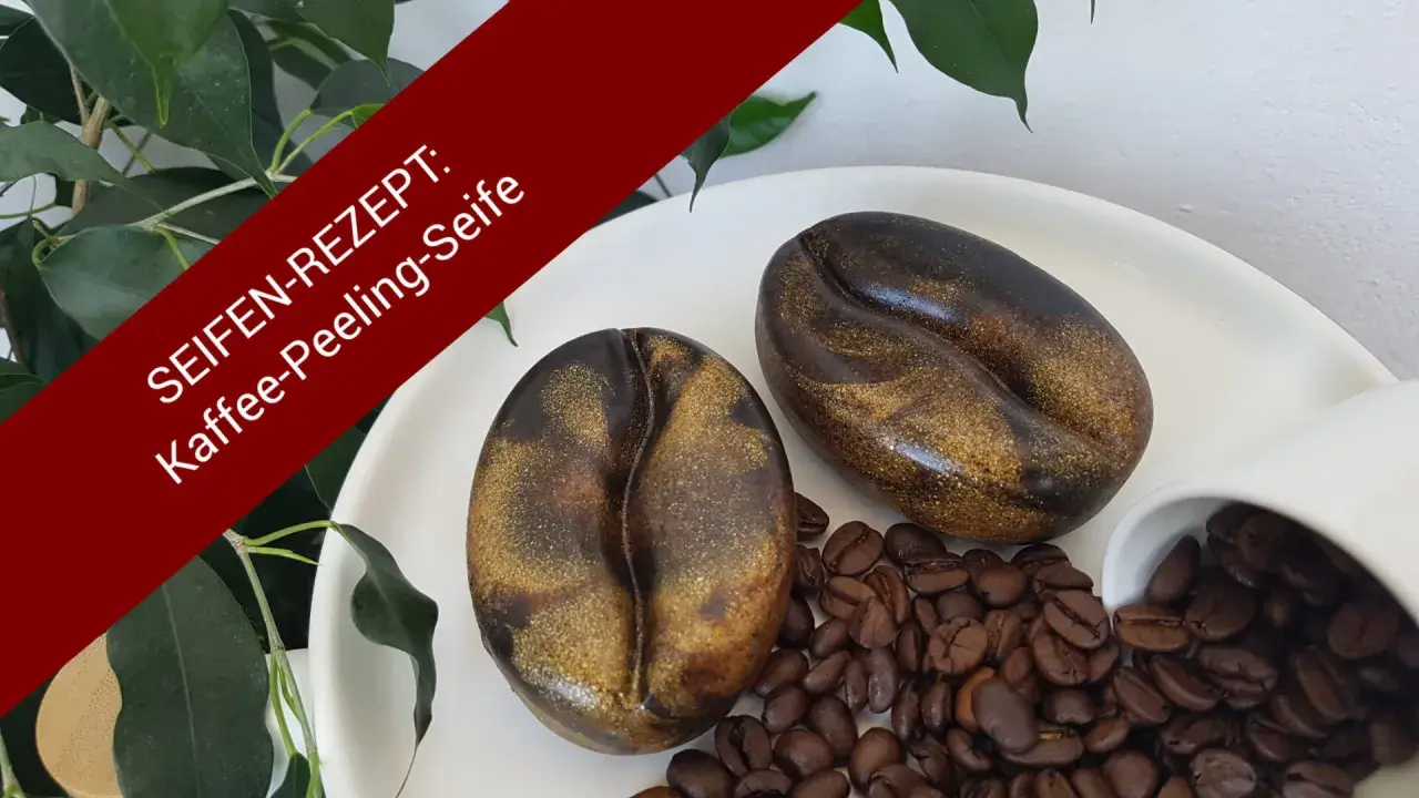 Zwei Kaffeebohnen-Seifen, ideal zum **peeling seife selber machen**. Mit Kaffeebohnen und Grünpflanzen dekoriert.