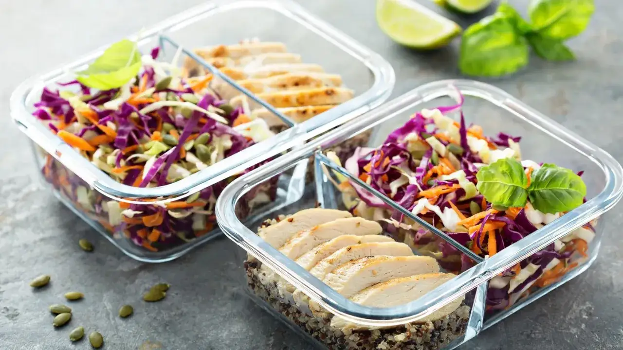 Gesunde Mahlzeiten für 10 kg abnehmen in Wechseljahren: Hähnchenbrust mit Quinoa und bunter Krautsalat in Meal-Prep-Boxen.