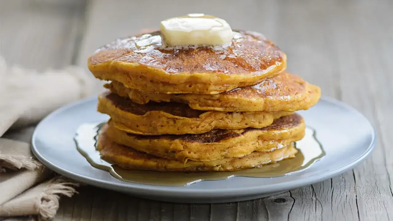 Stapel Kürbispfannkuchen mit Butter und Sirup. Leckere Morbus Crohn Rezepte für einen guten Start in den Tag.