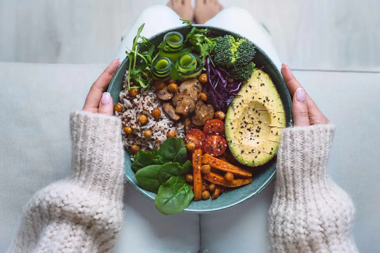 Bunte Bowl mit Reis, Kichererbsen, Avocado, Gem&uuml;se und Pilzen. Sie zeigt, warum sind Ballaststoffe wichtig f&uuml;r eine gesunde Ern&auml;hrung.