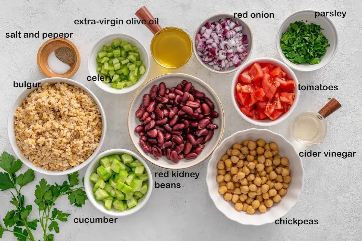 Zutaten f&uuml;r einen gesunden Bulgursalat: Bulgur, Kidneybohnen, Kichererbsen, Tomaten, Gurke, Sellerie, rote Zwiebeln, Petersilie, Oliven&ouml;l, Essig, Salz & Pfeffer.