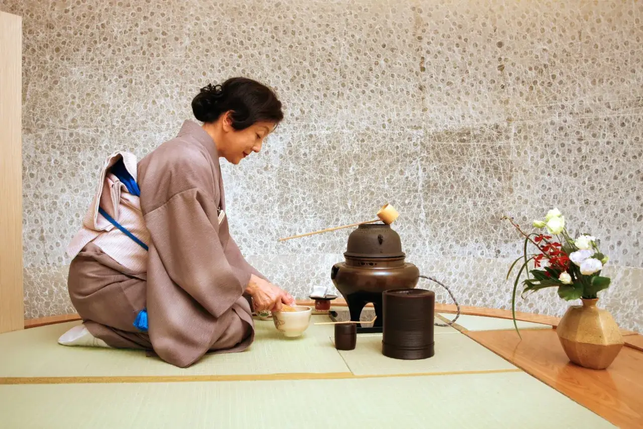 Frau in Kimono bereitet Tee zu. Die Sencha Tee Wirkung ist bekannt f&uuml;r ihre belebenden und konzentrationsf&ouml;rdernden Eigenschaften.