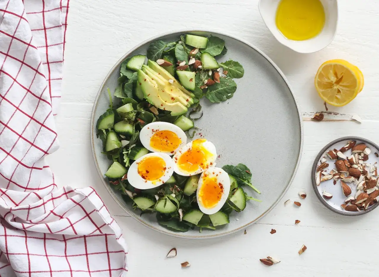 Salat mit weichgekochten Eiern, Avocado und Gurke. Eier bei Gicht sind eine gute Proteinquelle.