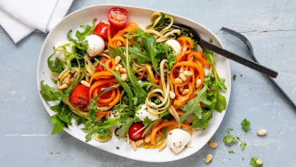 Bunter Zoodles Salat mit Karottenstreifen, Mozzarella-Kugeln, Kirschtomaten und Pinienkernen. Ein leichter Genuss!