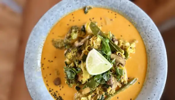 Ein cremiges Curry mit Brokkoli, Pilzen und Zuckerschoten, garniert mit Limette. Ein köstliches Beispiel für ayurvedische Rezepte.