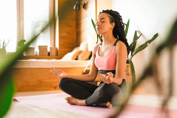 Eine junge Frau meditiert in Lotusposition. Ihre Augen sind geschlossen, Hände im Gyan Mudra. Eine Szene, die an eine Zen-Meister Geschichte erinnert, voller Achtsamkeit und innerer Ruhe.
